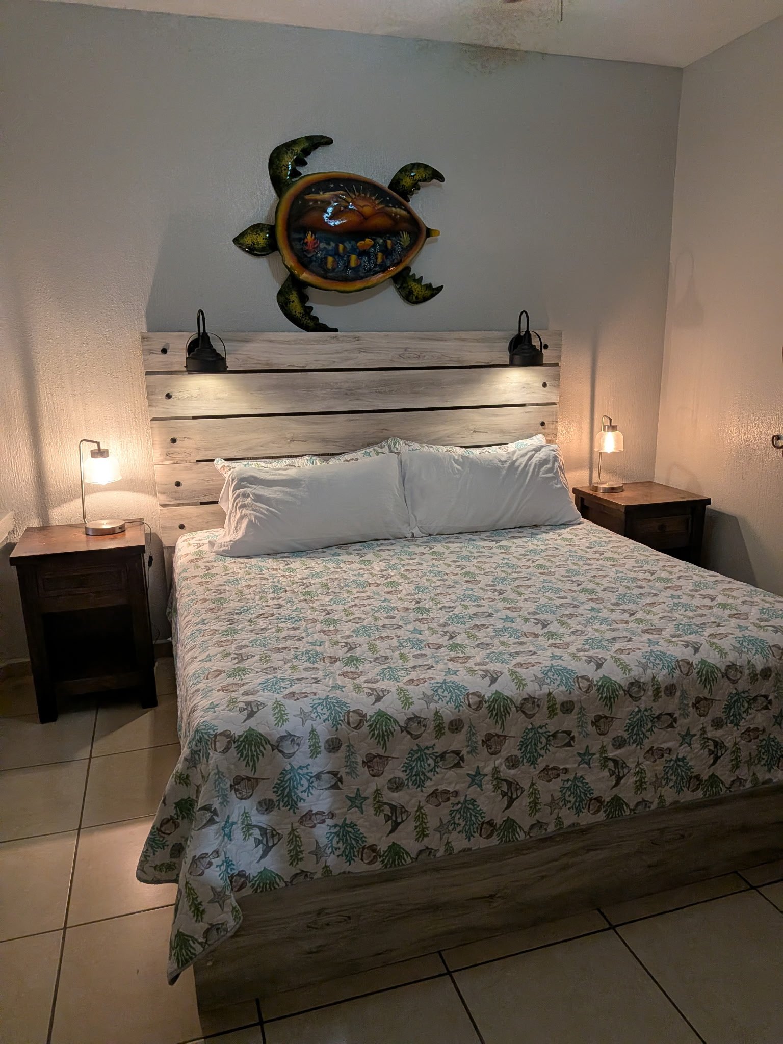 King bed with coastal bedding and turtle wall art
